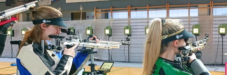 2 junior sport shooters during a match experiencing performance pressure