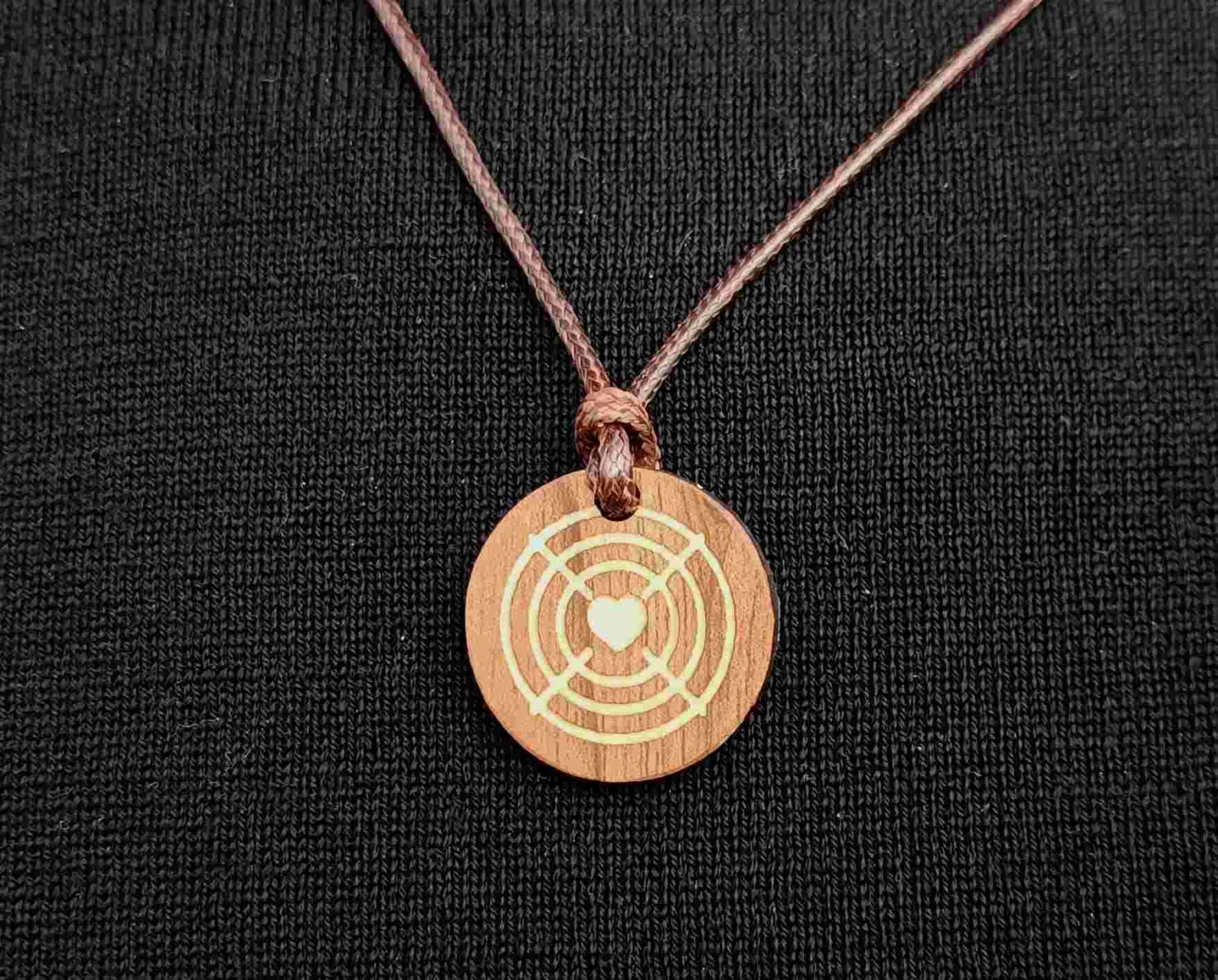 Aiming Art Lucky Charm pendant, 2-tone, on a black sweater