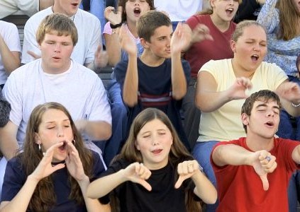 A group of young people booing, provoking the fear of social judgement