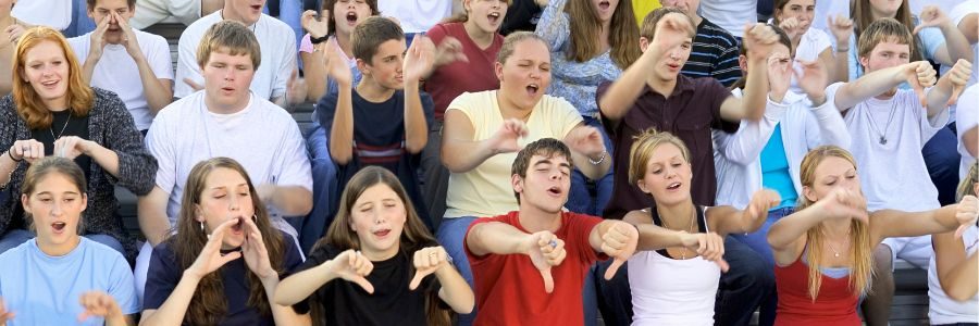 A group of young people booing, provoking the fear of social judgement