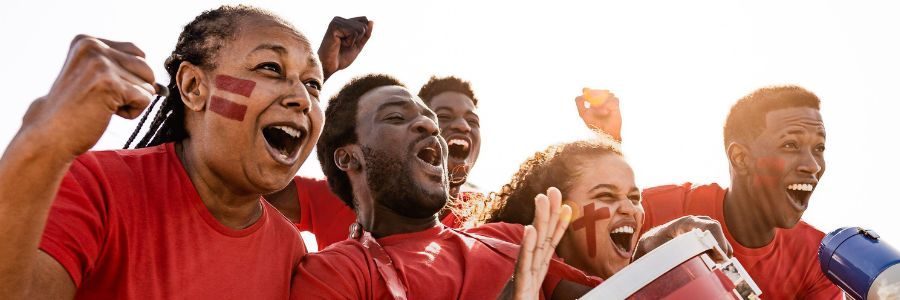 A group of students dressed in red loudly cheering for their sports team